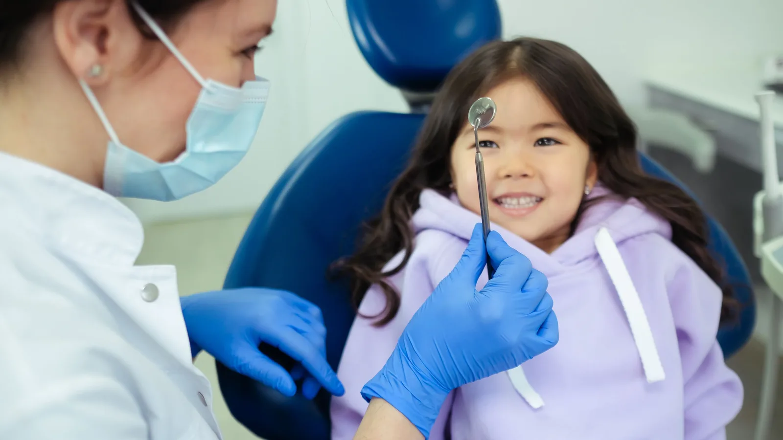 A dentist working gently with a young patient